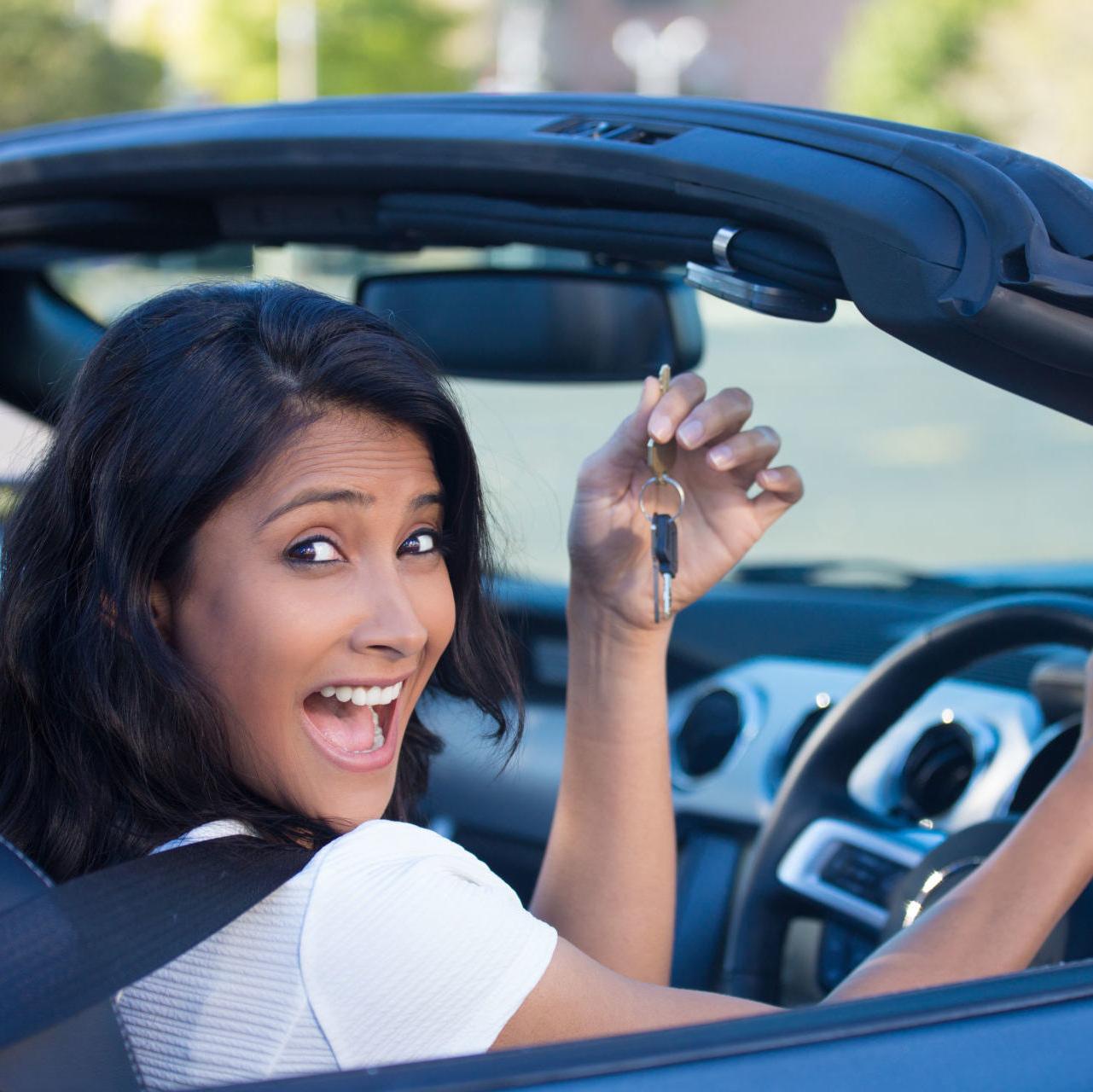 a woman smiles holding the keys to her new vehicle after getting pre-approved for an auto loan